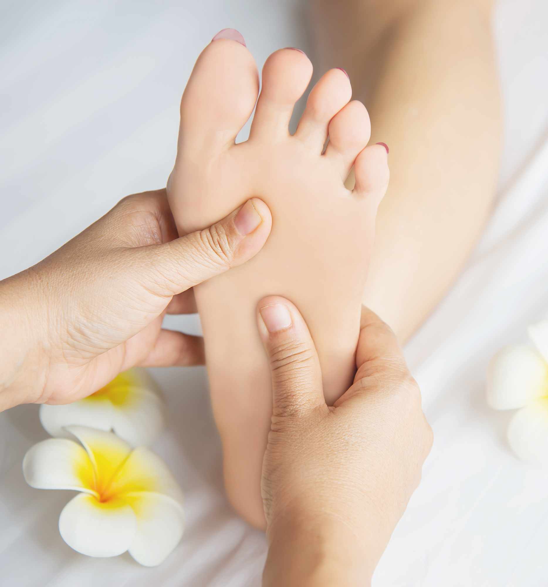 Woman receiving foot massage service from masseuse close up at hand and foot - relax in foot massage therapy service concept